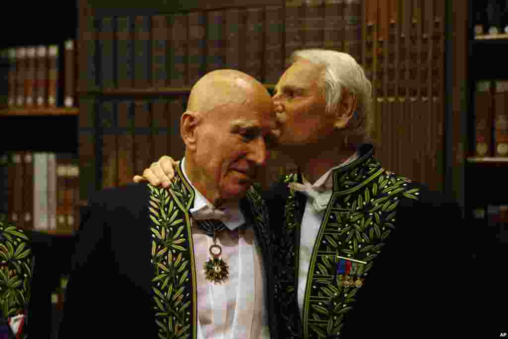 Photographer Sebastiao Salgado, left, is greeted by French Director and photographer Yann Arthus Bertrand as he was elected in the French Academy of Fine Arts.