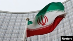 FILE - An Iranian flag flutters in front of the International Atomic Energy Agency (IAEA) headquarters in Vienna, Austria, Jan. 15, 2016. 