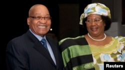 South Africa's President Jacob Zuma (L) smiles as he welcomes Malawi President Joyce Banda during a courtesy visit in Pretoria, July 31, 2012. 