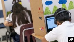 In this Friday, Sept. 18, 2020, photo students work in class at Meridien Public Charter School, in Washington. Several DC charter schools have been doing in-person teaching for small groups of students. (AP Photo/Andrew Harnik)