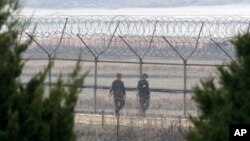 South Korean army soldiers patrol along a barbed-wire fence in Paju, near the border with North Korea, South Korea, March 27, 2014. 