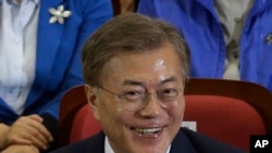 Moon Jae-in dari Partai Demokrat tersenyum saat pemimpin dan anggota partai tersebut menyaksikan hasil siaran lokal dari jajak pendapat dalam pemilihan presiden di Seoul, Korea Selatan, 9 Mei 2017.