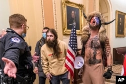 FILE - Supporters of President Donald Trump are confronted by U.S. Capitol Police officers outside the Senate Chamber inside the Capitol in Washington, Jan. 6, 2021.