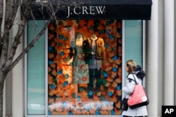 FILE - A shopper passes a display in the window of a J. Crew store in the Shadyside shopping district of Pittsburgh.