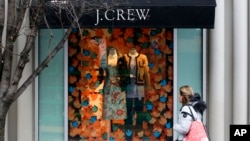 FILE - a shopper passes a display in the window of a J. Crew store in the Shadyside shopping district of Pittsburgh.