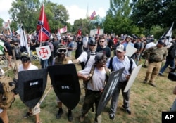 FILE - "Unite the Right" demonstrators clash with counter-demonstrators at the entrance to Lee Park in Charlottesville, Virginia., Aug. 12, 2017.