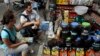 FILE - Tourists try coffee before making purchases at a shop in Hanoi, Aug. 20, 2013.