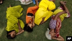 Indian villagers sleep in the shade of a tree on a hot summer day in Allahabad, India