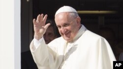 Pope Francis waves to reporters at Rome's Fiumicino international airport, Saturday, Sept. 19, 2015, as he boards his flight to Habana, Cuba, where he will start a 10-day trip including the United States. 