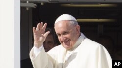 Pope Francis waves to reporters at Rome's Fiumicino international airport, Saturday, Sept. 19, 2015, as he boards his flight to Habana, Cuba, where he will start a 10-day trip including the United States. 