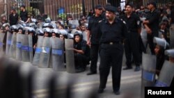 Police stand guard during a protest against the military council outside Egypt's parliament in Cairo, June 19, 2012. 