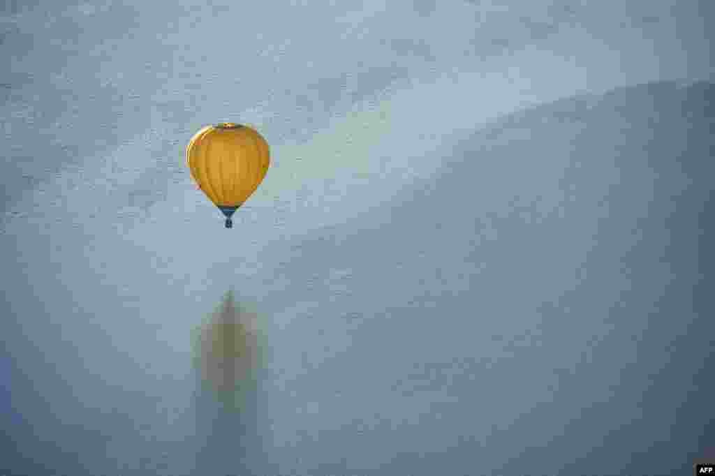 A hot air balloon flies over a lake at Moehnesee, western Germany.
