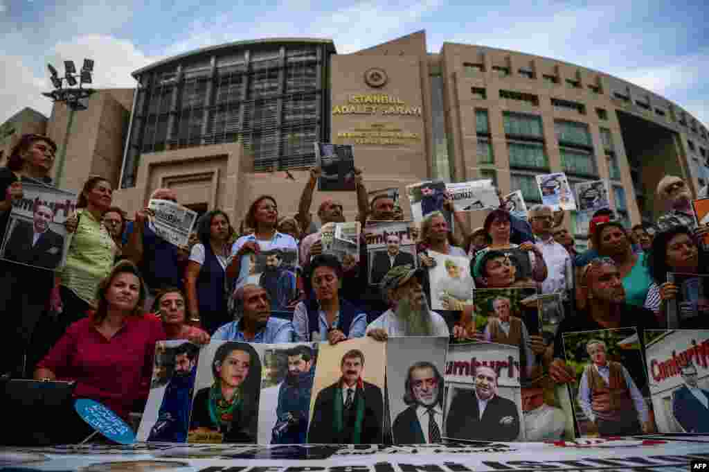 Protesters hold pictures of jailed Cumhuriyet journalists during a demonstration against their arrest outside the courthouse of Istanbul.