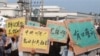 乌坎村民12月15日举着标语牌，高呼口号，要求中央政府介入