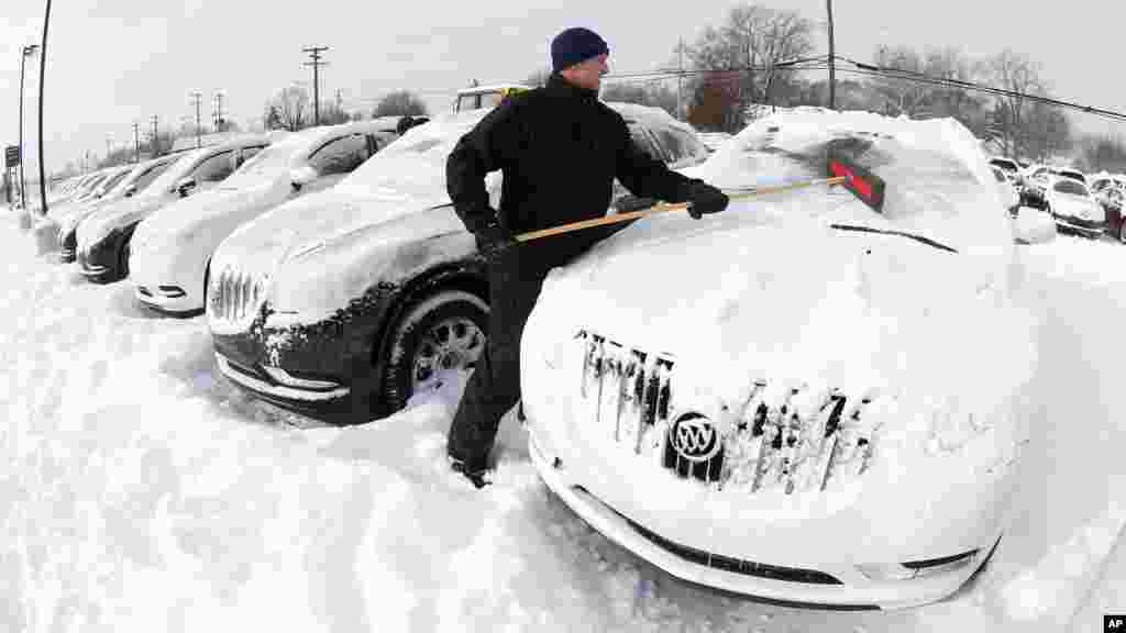 Matt Frame brushes off a Buick at Ray Laethem Buick-GMC in Detroit, Michigan, Jan. 6, 2014.