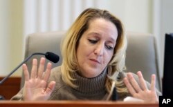 Lisa Britt throws up her hands as she answers a question by by attorney Marc Elias during the public evidentiary hearing on the 9th Congressional District investigation at the North Carolina State Bar, Feb. 18, 2019, in Raleigh, N.C.