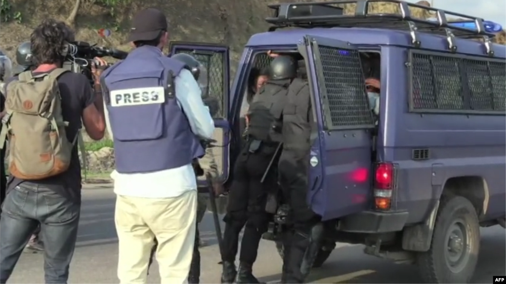 Les forces de l&rsquo;ordre embarquent dans un véhicule des manifestants arrêtés sous le regard des journalistes, à Libreville, Gabon, 31 août 2016.