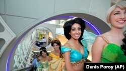 Para penggemar mengenakan kostum putri-putri karakter komik Disney, dalam ajang Comic COn INterantional Convention di San Diego, California, 17 Juli 2013. (FOto: dok).