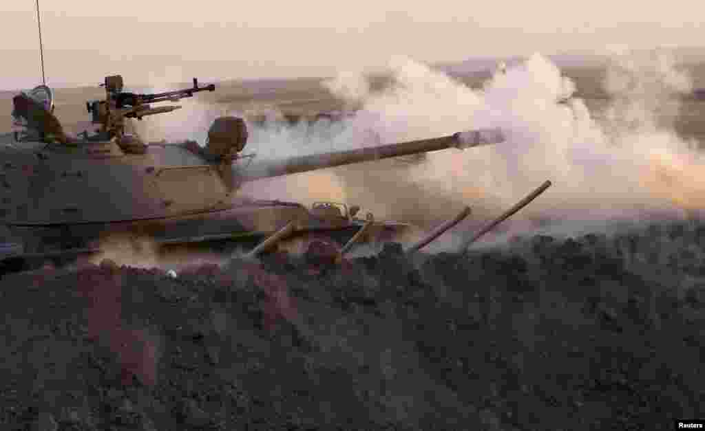 A tank belonging to Kurdish peshmerga troops fire at Islamic State militant positions from the frontline in Khazer, Aug. 14, 2014.