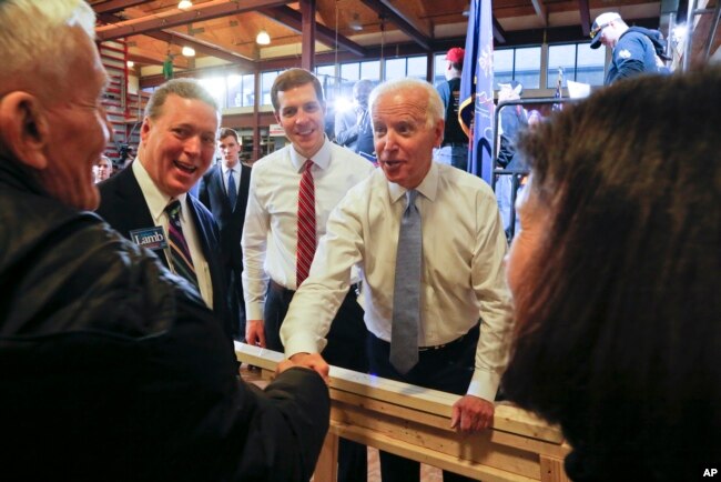 FILE - Conor Lamb, left center, the Democratic candidate for the March 13 special election in Pennsylvania's 18th Congress and former Vice President Joe Biden, center, work a crowd of supporters during a rally at the Carpenter's Training Center in Collier, Pennsylvania.