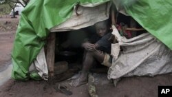 An internally displaced boy takes shelter from the rain at Kabo camp in northern Central African Republic.