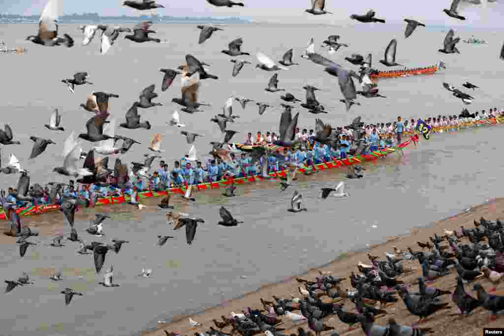 Doves fly as participants row their boat during the annual Water Festival on the Tonle Sap river in Phnom Penh, Cambodia.