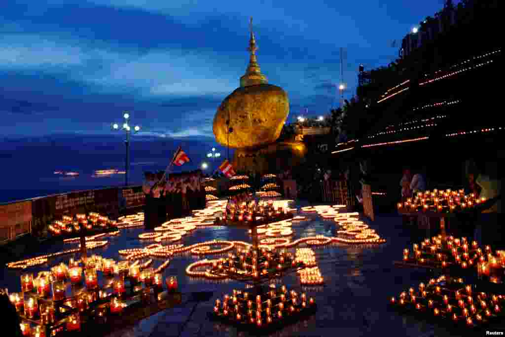 미얀마 짜익토에서 열린 보름달 축제를 기념하기 위해 불교신자들이 촛불에 불을 켜고 있다.
