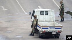 Tentara siaga dengan senjatanya melakukan patroli di Harare, Zimbabwe, Rabu (15/11). 
