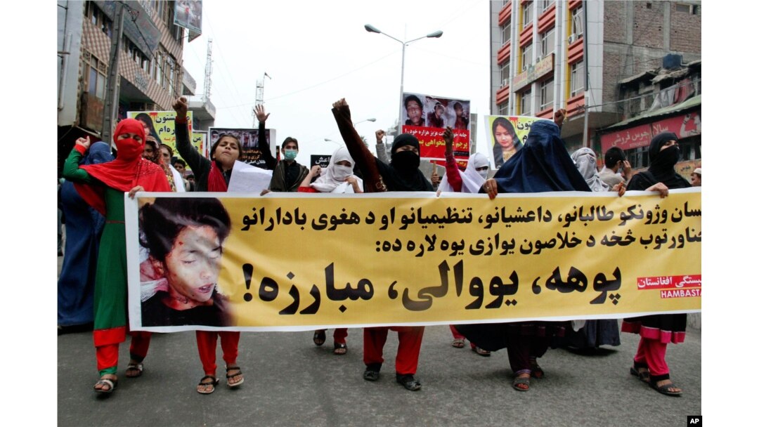 Women march as they hold photos showing ethnic Hazara victims who were allegedly beheaded by the Taliban, in Jalalabad, east of Kabul, Nov. 12, 2015.