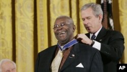 President Bush, right, bestows the Presidential Medal of Freedom to Blues Musician B.B. King, center, during a ceremony in the East Room of the White House in Washington, Dec. 15, 2006.
