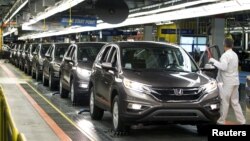 FILE - Production Associates inspect cars moving along the assembly line at a Honda manufacturing plant in Alliston, Ontario, March 30, 2015. 