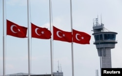 Turkish flags, with the control tower in the background, fly at half mast at the country's largest airport, Istanbul Ataturk, following yesterday's blast in Istanbul, Turkey, June 29, 2016.