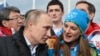 FILE - Russian President Vladimir Putin speaks with Olympic Village Mayor Elena Isinbaeva while visiting the Coastal Cluster Olympic Village ahead of the Sochi 2014 Winter Olympics in Sochi, Russia. 
