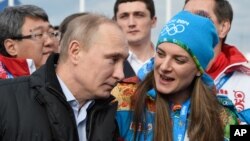 Le président russe Vladimir Putin parle avec la maire du village olympique Elena Isinbaeva lors des Jeux d'hiver de Sochi, Russie, le 5 février 2014. 