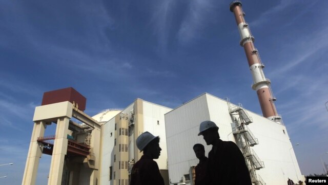 Trabajadores iraníes en frente a la planta nuclear de Bushehr, al sur de Teherán.