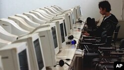 A Chinese man uses the computer at an internet cafe in Beijing Friday. The Internet opens new horizons, but also opens the way for new abuses. (AP Photo/Ng Han Guan)