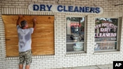 Jay McCoy cubre las ventanas de su negocio con madera en anticipación a la llegada del huracán Milton, el 7 de octubre de 2024, en New Port Richey, Florida. 