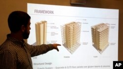In this Nov. 15, 2016, file photo, engineer Eric McDonnell shows diagrams of skyscraper construction using cross-laminated timber in Portland, Oregon. City officials have approved a construction permit for the first all-wood high-rise in the nation.