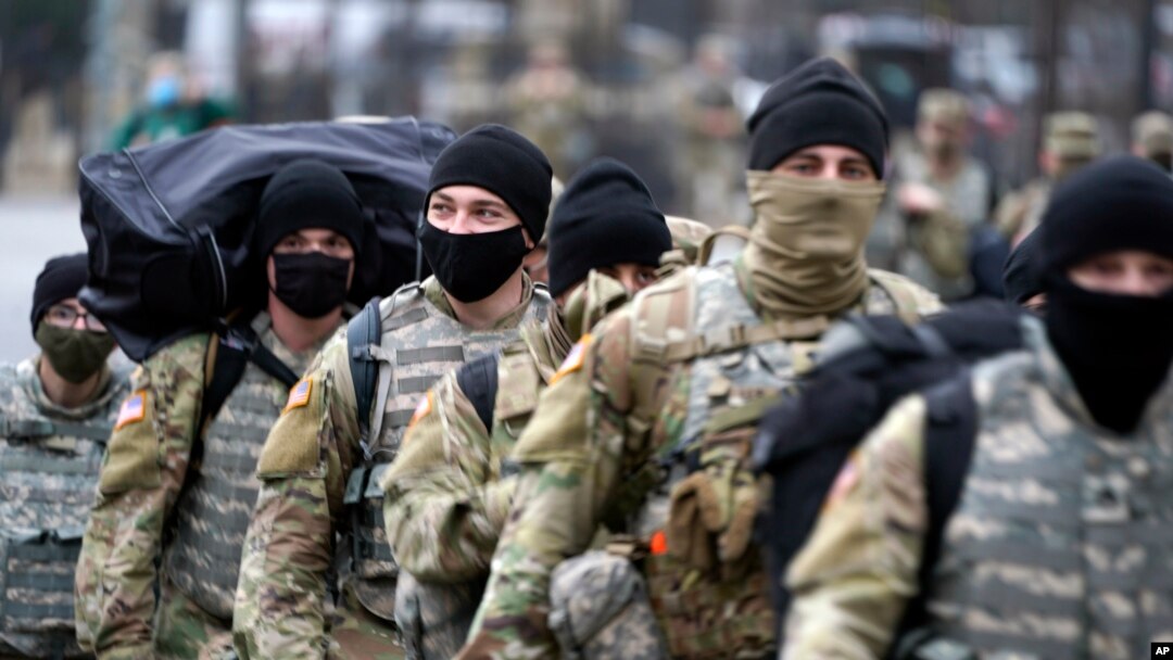Sejumlah tentara Garda Nasional melintas di dekat Capitol, Washington, Minggu, 17 Januari, 2021, sementara pengamanan makin diperketat menjelang pelantikan Presiden terpilih Joe Biden dan Wakil Presiden terpilih, Kamala Harris.