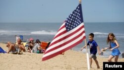 Niños juegan en la playa de Ocean City en Maryland durante el fin de semana largo por el Día de los Caídos, que marca el comienzo de la temporada de verano en Estados Unidos. Mayo 23, 2020.