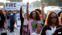 FILE - Demonstrators march in Arlington, Texas, Sept. 16, 2018, to protest the recent killings of two black men by police: Botham Jean and O'Shae Terry. On Friday, Amber Guyger, a former police officer, was charged with murder in the shooting death of Jean.