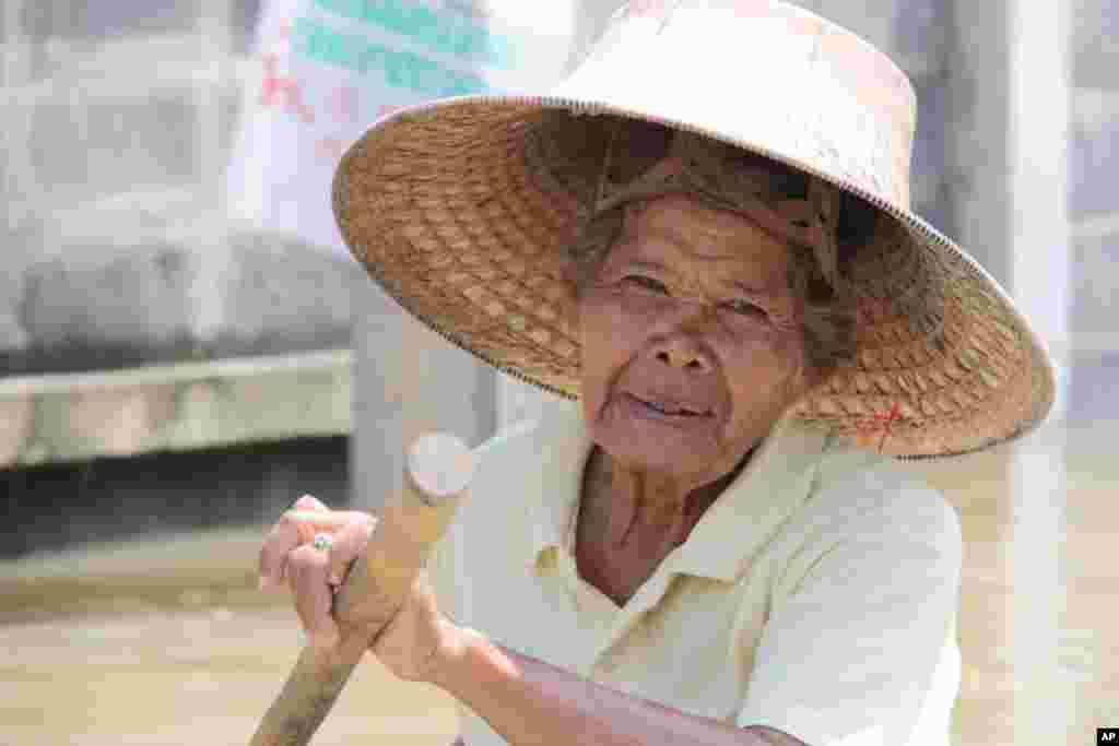A woman paddles though her flooded neighborhood, Oct. 6, 2011. (VOA - D. Schearf)