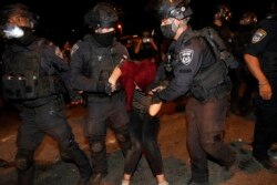 Israeli police detain a Palestinian demonstrator during a protest against the planned evictions of Palestinian families in the Sheikh Jarrah neighborhood of east Jerusalem, May 8, 2021.