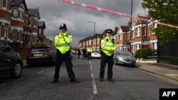 FILE - British police officers secure a cordon in a residential street in north-west London on April 28, 2017, after they carried out a specialist entry into an address as part of a Counter Terrorism investigation.