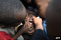 FILE - A community health worker administers a polio vaccine during a polio immunization campaign in Kiamako, Nairobi, Kenya, July 19, 2021.