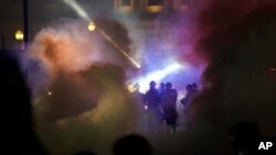 FILE - Police in riot gear respond during clashes with protesters in Kenosha, Wis., Aug. 25, 2020.