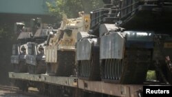 ລົດຖັງ M1 Abrams tanks ແລະ ລົດຫຸ້ມເກາະອື່ນໆຕັ້ງຢູ່ເທິງລາງລົດໄຟໃນລັດ ວໍຊິງຕັນ, ສະຫະລັດ, 2 ກໍລະກົດ 2019. 