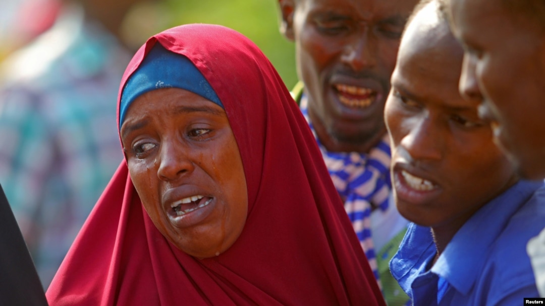 Seorang perempuan dan beberapa pria menangisi kematian kerabat mereka yang tewas dalam operasi pasukan Somalia didukung AS di Mogadishu, Jumat (25/8). 
