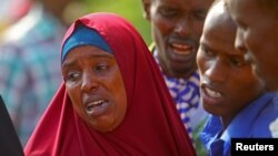 Seorang perempuan dan beberapa pria menangisi kematian kerabat mereka yang tewas dalam operasi pasukan Somalia didukung AS di Mogadishu, Jumat (25/8). 