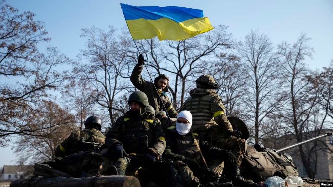 Anggota pasukan Ukraina dan kendaraan lapis baja berpatroli di dekat Debaltseve pasta penandatanganan kesepakatan gencatan senjata di Minsk (12/2).